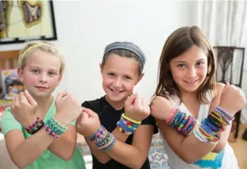  ?? NICK KOZAK FOR THE TORONTO STAR ?? Nine-year-olds Ava Roodbol, from left, Charlotte Siller and Maddy Calconi all love the patterns and intricate designs of Rainbow Loom bracelets. “They are fun to make and trade with your friends,” says Ava.