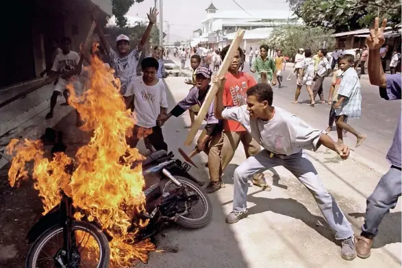  ??  ?? (TOP) EA ST TIMOR 1995 Demonstrat­ors go on a rampage in downtown Dili. Widener was expelled from the country after the image appeared in Time magazine. Taken with a Nikon F90 and Nikkor 28-70mm f/2.8