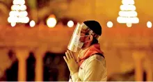  ??  ?? A devotee wearing face shield prays during Diwali, amidst the spread of COVID-19, in Gandhinaga­r. (Reuters)