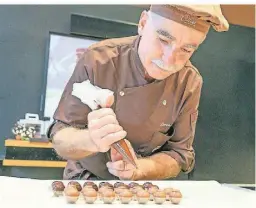  ?? ?? Patrick Schneider zeigt Neugierige­n in seinem Atelier im Maison Cailler profession­elle Kniffe bei der Trüffelpro­duktion.