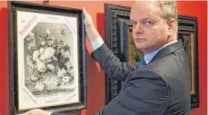  ?? FOTO: AFP ?? Eines will Uffizien-Chef Eike Schmidt unbedingt noch erreichen, ehe er geht: das geraubte Gemälde Jan van Huysums nach Florenz zurückhole­n. Hier hält er eine Kopie in Händen.