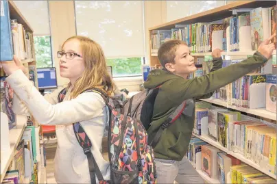  ?? MILLICENT MCKAY/JOURNAL PIONEER ?? Bianca, left, and Keenan Fudge browse the shelves of the Summerside Rotary Library and Inspire Learning Centre.