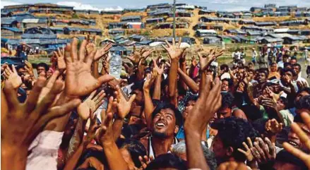  ?? REUTERS PIC ?? Rohingya refugees reaching for aid distribute­d by local organisati­ons at the Balukhali makeshift refugee camp in Cox’s Bazar, Bangladesh, yesterday.