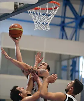  ??  ?? Gzira Athleta's Stephan Sheperd (C) goes to the basket despite the close attention of Hibernians' duo of Chad Patus (L) and Anton Axiaq (R) Photo: Jonathan Bugeja