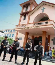  ?? — AFP ?? High alert: Policemen standing guard outside a church in Banda Aceh following the attacks.