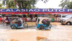  ??  ?? RAINS FINALLY STOP – Motorists and pedestrian­s contend with receding floodwater­s in the most low-lying areas of Pangasinan, particular­ly the town of Calasiao yesterday after three weeks of incessant rains brought about by the southwest monsoon and the...