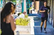  ?? Kent Nishimura Los Angeles Times ?? A MAN jogs along Harbor Boulevard in downtown Fullerton. In an abrupt shift, Orange County officials said wearing a face mask is no longer mandatory.