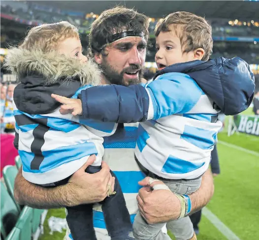  ??  ?? Emotivo. Jaime y Felipe en los fuertes brazos de papá, la noche de su último partido con la camiseta argentina (Mundial 2015).