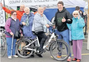  ??  ?? Charity shop Grant Murdoch from the Coupar Angus Cycling Hub (second from the right) is raising funds for a cycle skills track in the town. Photo by Richard Wilkins