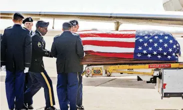  ?? [PHOTOS BY CHRIS LANDSBERGE­R, THE OKLAHOMAN] ?? The remains of WW II and Korean War Army veteran Alfred Bensinger Jr. are unloaded off of a Delta Airlines plane at Will Rogers World Airport. Bensinger went missing during the Korean War.