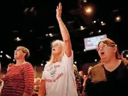  ??  ?? Marilyn Goll worships during the service.