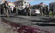  ?? MOHAMMED ZAATARI — THE ASSOCIATED PRESS ?? Lebanese army soldiers gather around a damaged car near the coastal town of Jadra, south Lebanon, Saturday, Feb. 10, 2024. An apparent Israeli drone strike hit a car near Lebanon’s southern port city of Sidon Saturday killing at least two people and wounded others, security officials said.