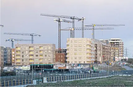  ?? ?? Cranes above residentia­l apartments under constructi­on on the Barking Riverside developmen­t in London on Wednesday.