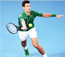  ?? — AFP photo ?? Djokovic hits a return against Struff during their men’s singles match on day one of the Australian Open tennis tournament in Melbourne.