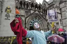  ?? KIN CHEUNG / AP ?? A protester stands outside the Royal Courts of Justice in London, Wednesday. Julian Assange’s lawyers are on their final U.K. legal challenge to stop the WikiLeaks founder from being sent to the United States to face spying charges.