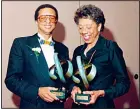  ?? (AP) ?? In this May 13, 1988 file photo, tennis players Arthur Ashe (left), and Althea Gibson pose while holding trophies after being inducted into the Eastern Tennis Associatio­n Hall of Fame in New York. Gibson won an amazing 11 Grand Slam titles in three years from 1956-58, including the French Open, Wimbledon and US Open.