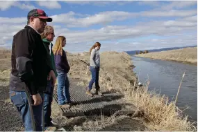  ?? ASSOCIATED PRESS ?? In this March 2, 2020, file photo, farmer Ben Duval with his wife, Erika, and their daughters, Hannah, third from left, and Helena, fourth from left, stand near a canal for collecting run-off water near their property in Tulelake, Calif. The Klamath Basin, a vast and complex water system that spans Oregon and California, is in the throes of the worst drought in recorded history, with water flows in the tributarie­s of the Klamath River that are as low as they have been in a century. Federal officials are expected to announce the water allocation­s for the season this week and it’s possible that farmers might not get any water at all.
