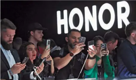  ?? ?? People look at Honor Magic6 Pro phones, as Honor unveiled its new products, ahead of the 2024 Mobile World Congress, in Barcelona on Sunday. — Xinhua