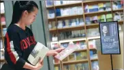  ?? LONG WEI / FOR CHINA DAILY ?? A reader selects books written by Louis Cha at a display set up to honor the novelist at a bookstore in Hangzhou, Zhejiang province, on Wednesday.