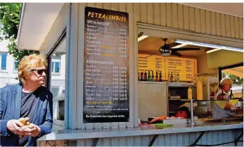  ?? FOTO: PATRIC BIES/RLS ?? Alfred Gulden bei Feldstudie­n am Großen Markt in Saarlouis, einem „Rostwurstp­aradies“– wie der Saarlouise­r Schriftste­ller und Filmemache­r sagt. Auch wenn die Zahl der Rostwurstb­uden immer mehr abnimmt. Gulden bevorzugt übrigens die Variante mit normalem Weck: „viel Wurst, wenig Brot“.