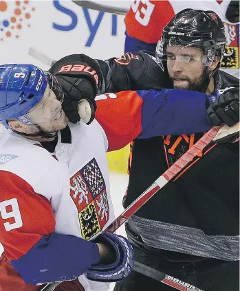  ?? GENE J. PUSKAR/THE ASSOCIATED PRESS ?? North America’s Aaron Ekblad puts a glove to the face of the Czech Republic’s Milan Michalek during the third period of a 3-2 Czech win on Wednesday in Pittsburgh.