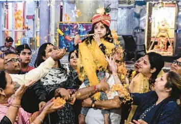  ?? NARINDER NANU/GETTY-AFP ?? Hindu devotees carry a child dressed as the god Lord Krishna during Holi celebratio­ns, the spring festival of colors, Monday at a temple in Amritsar. Holi traditions vary across India. In most parts, the holiday will be celebrated Wednesday, turning the streets and lanes into playground­s with people of all faiths joining the festivitie­s.