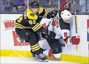  ?? [CHARLES KRUPA/THE ASSOCIATED PRESS] ?? Boston’s Brad Marchand, left, checks New Jersey’s Will Butcher into the boards during Tuesday’s game.
PENGUINS 3, HURRICANES 1: CANADIENS 4, AVALANCHE 2: FLYERS 3, RED WINGS 2, OT: