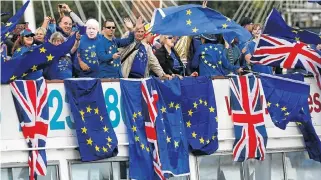  ?? Reuters ?? Turning tide: AntiBrexit, pro-EU Remain supporters wave flags as they travel up and down the River Thames, outside the Houses of Parliament in London. /