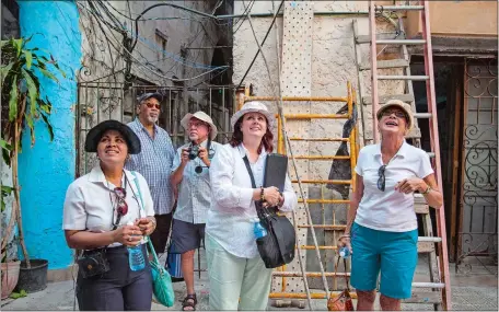  ?? DESMOND BOYLAN/AP PHOTO ?? SmarTours tour director Pamela Boudrot, center, and local tour guide Enedis Tamayo, left, lead a group of tourists in Havana last week. The thaw in U.S.-Cuba relations has many small and medium-sized companies thinking about doing business with the...