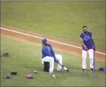  ?? COLE BURSTON ?? Toronto Blue Jays’ Vladimir Guerrero Jr. sits on a bin beside teammate Teoscar Hernandez during batting practice at summer training in Toronto, Sunday, July 19, 2020.