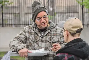  ?? Ned Gerard/Hearst Connecticu­t Media ?? Chris Ortiz of the Connecticu­t Harm Reduction Alliance speaks with a man while making nightly rounds in CTHRA’s mobile minivan in Hartford.