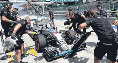  ?? Picture: AP. ?? Mechanics work on Lewis Hamilton’s car during a pit stop in yesterday’s practice session.