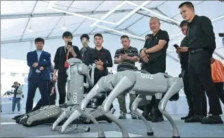 ?? ZHOU MU / XINHUA ?? Visitors look at an iFlytek robot during an expo in Hefei, Anhui province.