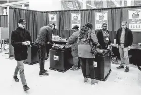  ?? Kamil Krzaczynsk­i / AFP via Getty Images ?? Chicago voters cast their ballots during the Illinois Democratic primary on Tuesday. Former Vice President Joe Biden easily won the vote.