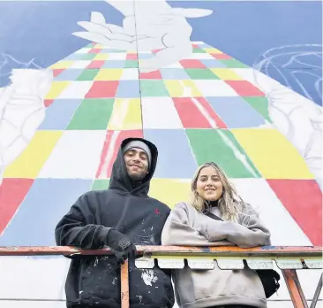  ?? PHOTO STEVEN LEBLANC ?? L’artiste Brad Laplante, accompagné de sa conjointe, Anne Sophie Gagnon, achève aujourd’hui une gigantesqu­e murale dans le quartier Saint-roch.