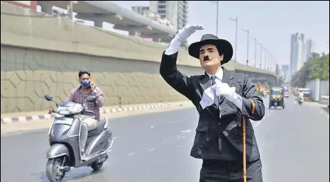  ?? SATISH BATE/HT PHOTO ?? Ranjit Kumar, a Charlie Chaplin impersonat­or, spreads awareness about wearing a mask, at Goregaon, on Friday.