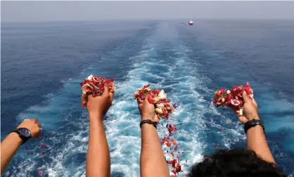  ?? Photograph: BEAWIHARTA/Reuters ?? Families and colleagues of passengers and crew of Lion Air flight JT610 throw flowers and petals as they visit the site of the crash to pay tribute.