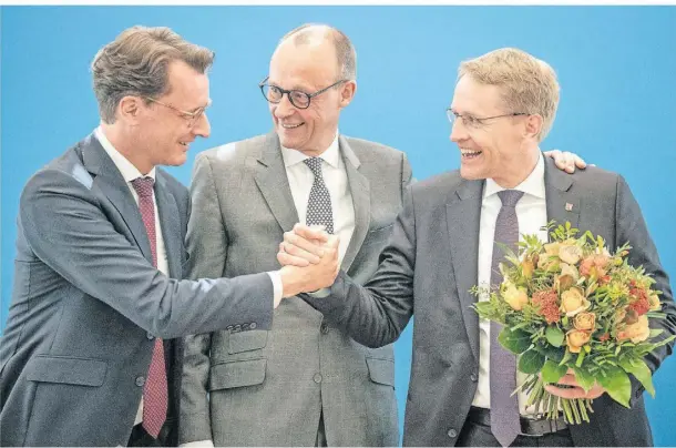  ?? FOTO: DPA ?? Daniel Günther (r.) feierte mit Hendrik Wüst (l.) und CDU-CHEF Friedrich Merz am Montag seinen Sieg.