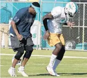  ?? TAIMY ALVAREZ/STAFF PHOTOGRAPH­ER ?? Miami wide receivers coach Shawn Jefferson works with DeVante Parker during camp on Wednesday. Jefferson says Parker will be a “monster” this season.