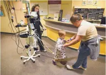  ??  ?? Ingrid Rivas, right, helps her son, Denis, get some post-surgical exercise with a walk through the halls of Presbyteri­an Hospital, assisted by registered nurse Cherie Sanborn.