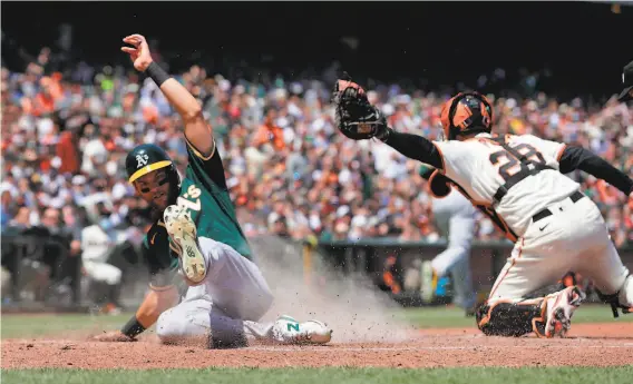  ?? Carlos Avila Gonzalez / The Chronicle ?? The A’s Chad Pinder avoids the tag by Giants catcher Buster Posey to score on a single by Aramis Garcia in the sixth inning of the A’s win in San Francisco.