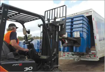  ?? NEWS PHOTO COLLIN GALLANT ?? Mike Langlois, of the city's solid waste department, loads blue recycling carts for deliveries to homes that began on Tuesday. The process of delivering 23,000 of the carts that are stockpiled at hte city's Marshall Avenue public works yard, could...