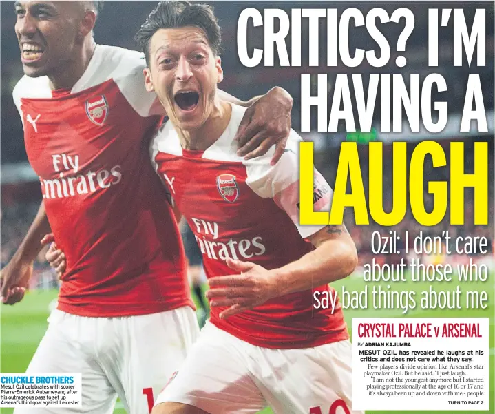  ??  ?? CHUCKLE BROTHERS Mesut Ozil celebrates with scorer Pierre-emerick Aubameyang after his outrageous pass to set up Arsenal’s third goal against Leicester