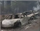  ?? THE ASSOCIATED PRESS FILE PHOTO ?? Burned-out hulks of cars abandoned by their drivers sit along a road in Paradise. A lack of escape routes out of Paradise caused many people fleeing the 2018 Camp Fire to abandon their vehicles and run for their lives.