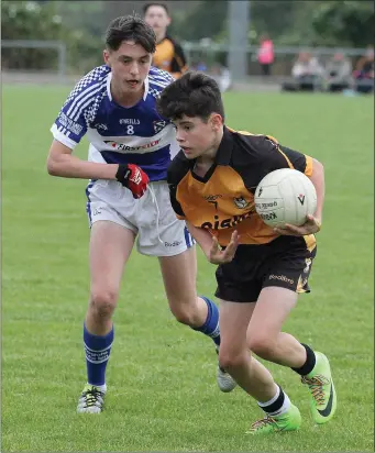  ??  ?? Kilrush’s Charlie O’Sullivan in action against Oylegate-Glenbrien’s Dara Casey during the New Ross Standard Under-14 Division 3 football championsh­ip.