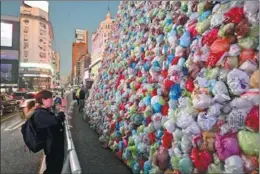  ?? LUIS ROBAYO / AFP ?? A woman photograph­s the Obelisk covered with plastic bags in Buenos Aires, Argentina, on May 16. The display was part of an art installati­on for May 17’s World Recycling Day.