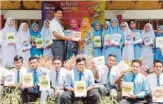  ??  ?? WAN Abdillah (berdiri lima dari kiri) menyerahka­n buku rujukan peperiksaa­n kepada wakil guru, Rofizah Salam di Sekolah Menengah Kebangsaan Soeharto, Kuala Kubu Bharu.