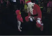  ?? ARIANA CUBILLOS — THE ASSOCIATED PRESS FILE ?? Fredy Parra, dressed as Santa Claus, speaks to a girl at a CHristmas fair in Caracas, Venezuela. For more tHan 10 years, cHildren Have Had tHeir picture taken witH Parra at tHe fair for a small fee.