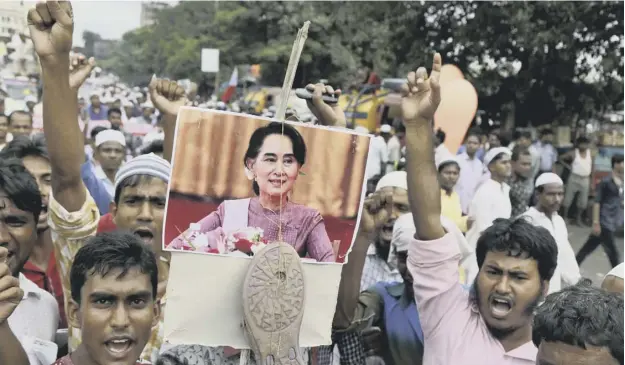  ??  ?? 0 Muslims in India protest about the treatment of Rohingya by Myanmar, hanging a sandal – a traditiona­l Muslim form of insult – from a picture ofaung San Suu Kyi