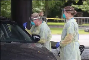  ?? The Sentinel-Record/Richard Rasmussen ?? TESTING: UAMS LPN Kim Paty, left, and Army National Guard medic PFC Sydney Carr perform a COVID-19 test on an individual at the Hot Springs Farmers & Artisans Market on Monday.